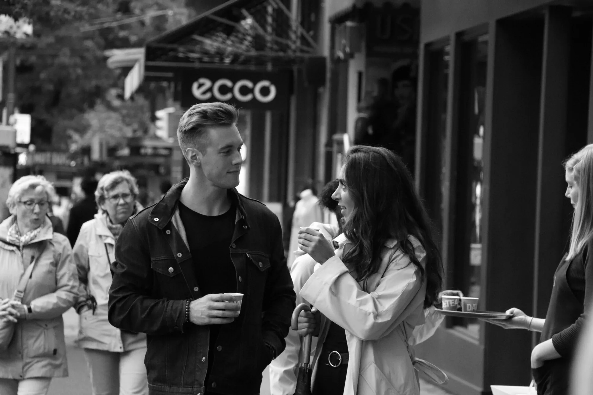 A man and woman talking closely on a city street, representing authentic connection and the start of healthier love.