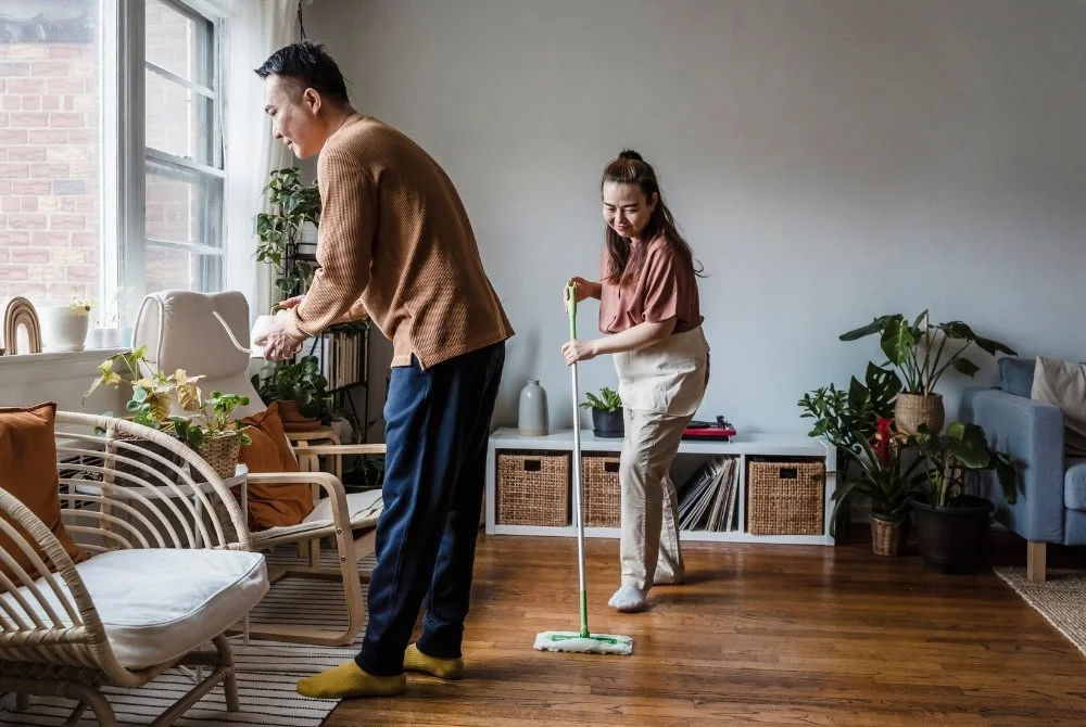 Una pareja limpiando su hogar junta.