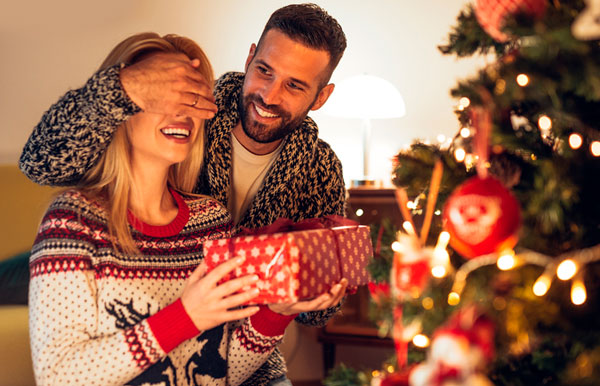 A couple opening a Christmas gift together.