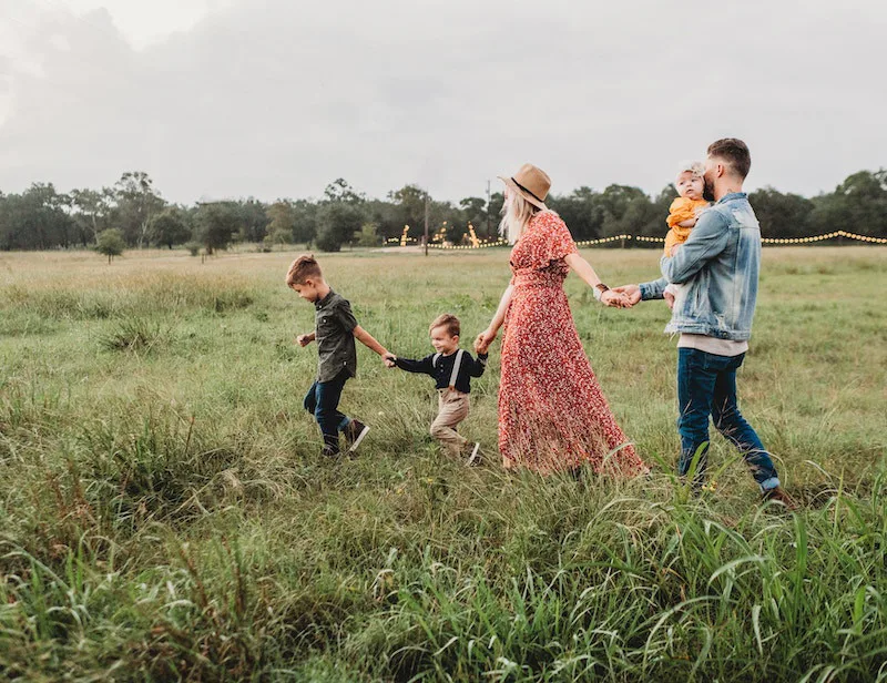 Family walking through a grassy field with children, symbolizing long-term commitment, intimacy, and shared future after marriage.