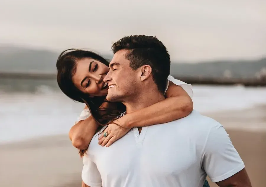 Happy couple embracing by the water, representing healthy attraction, trust, and emotionally secure love after growth.