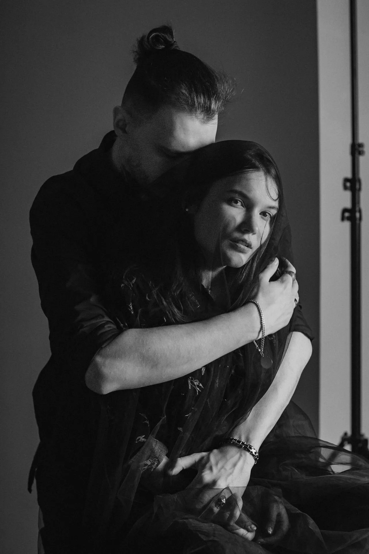 Black and white portrait of a couple embracing closely, expressing emotional support, protection, and deep partnership.