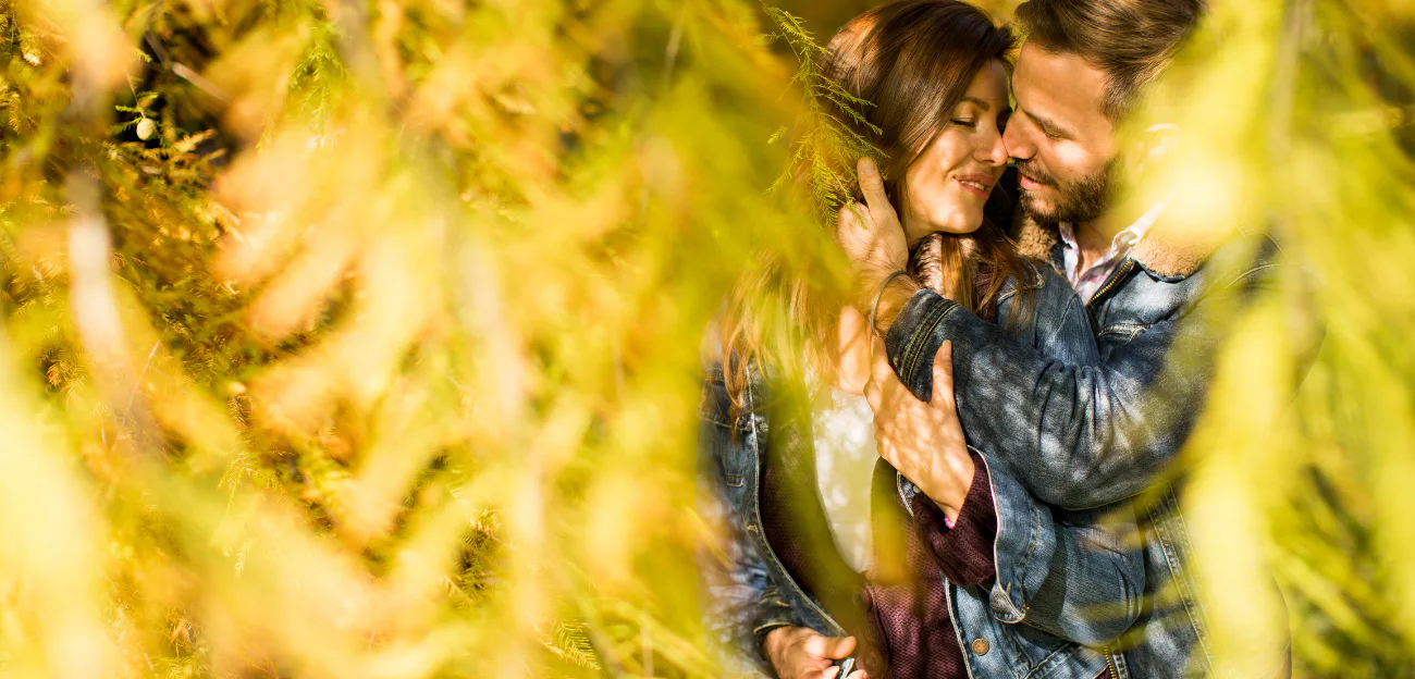 A couple embracing tenderly outdoors among golden leaves, representing renewed intimacy, affection, and falling in love again.