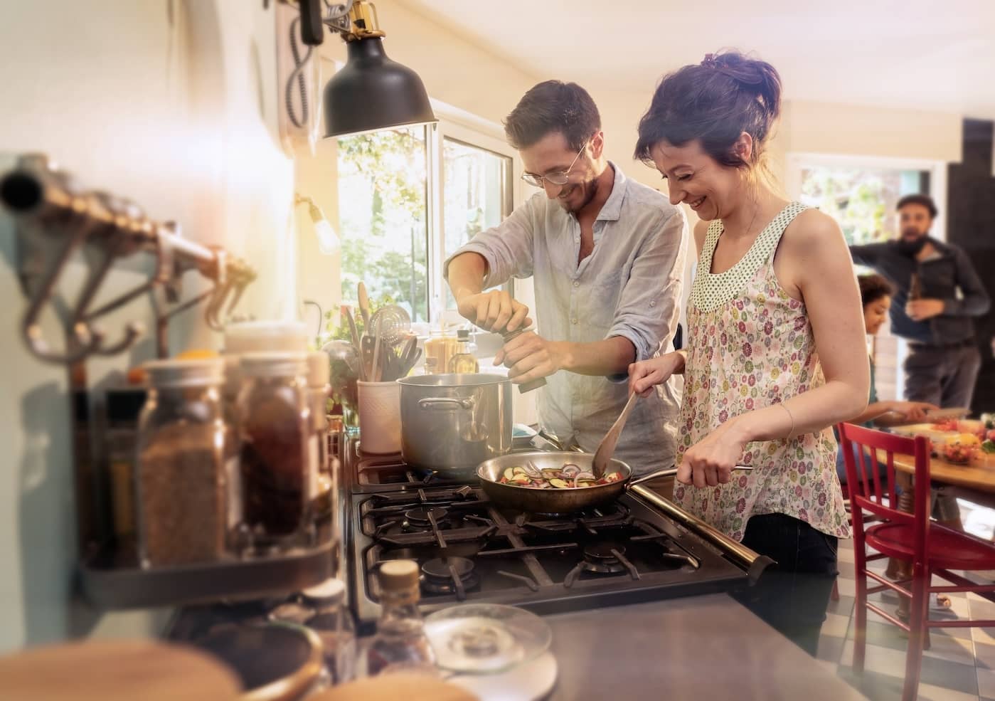 Grupo de amigos cocinando juntos en una cocina acogedora, representando la amistad y los recuerdos compartidos de Año Nuevo