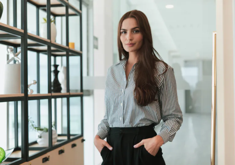Confident woman standing in a modern office, symbolizing inner strength, independence, and grace as a bride.